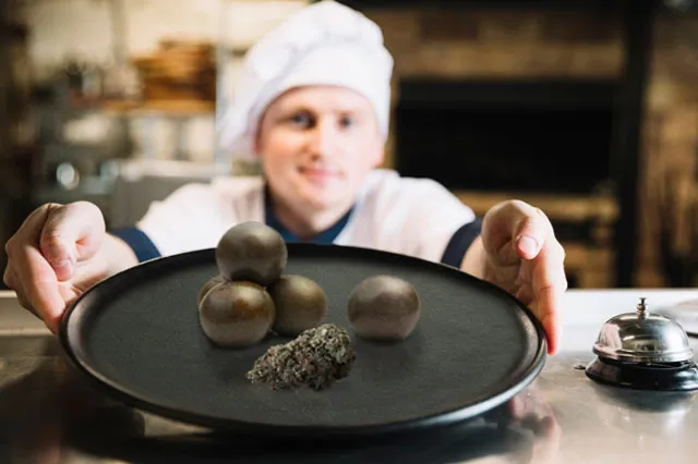 Chef presentando un plato de temple balls nepalesas y cogollo 